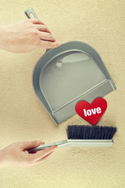 Hand sweeping heart from the floor — Stock Photo, Image