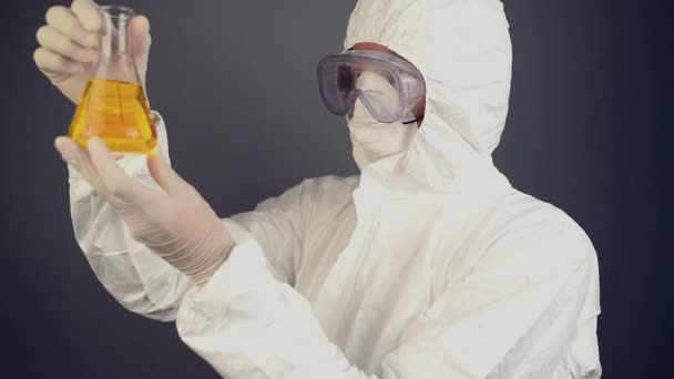 Chemical scientist in protective clothing mixing chemical liquids — Stock Video