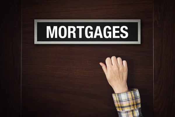 Hand is knocking on Mortgages door — Stock Photo, Image