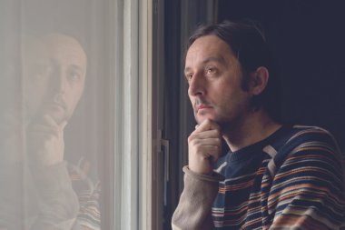 Pencerenin kenarında üzgün adam