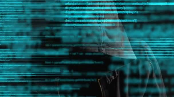 Ansiktslösa hooded anonym datorhackare med programkod från monitor — Stockvideo