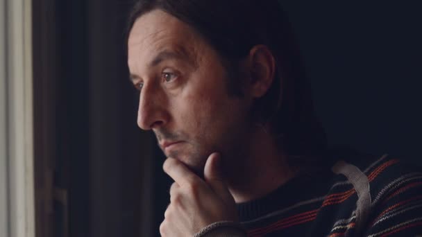 Mid adult caucasian man relaxing and drinking a cup of tea, looking out of window — Stock Video