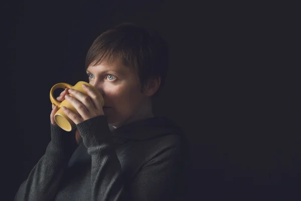 Beautiful Woman Drinking Coffee in Dark Room — Stock Photo, Image