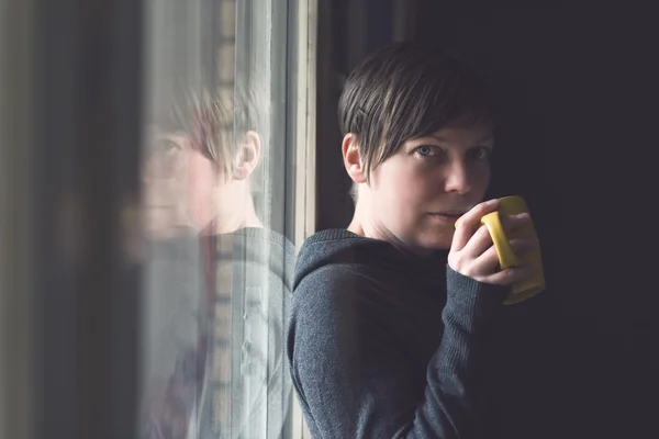 Bella donna che beve caffè in camera oscura — Foto Stock