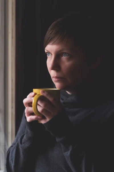 Triste sozinho mulher bebendo café no quarto escuro — Fotografia de Stock