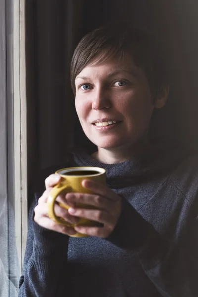 Hermosa mujer tomando café en habitación oscura —  Fotos de Stock