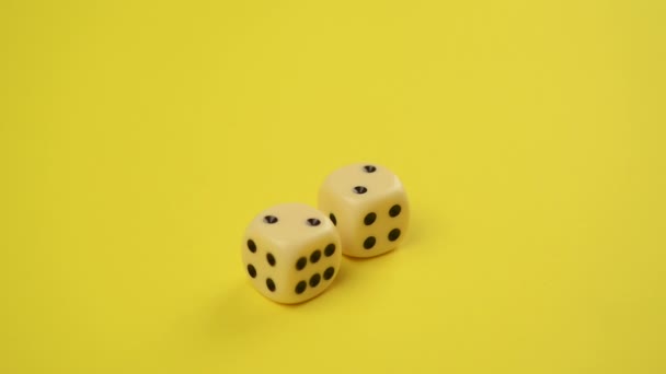 Toczenia kości na żółtym tle jako hazard i prawdopodobieństwo koncepcja, rzucając kostką — Wideo stockowe