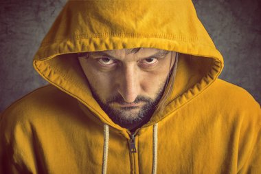 Adam sarı kapşonlu ceket giyiyor