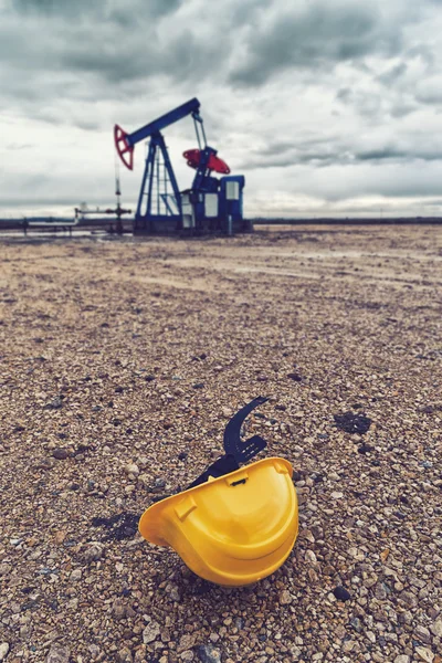 Bomba de óleo de abóbora e capacete protetor — Fotografia de Stock