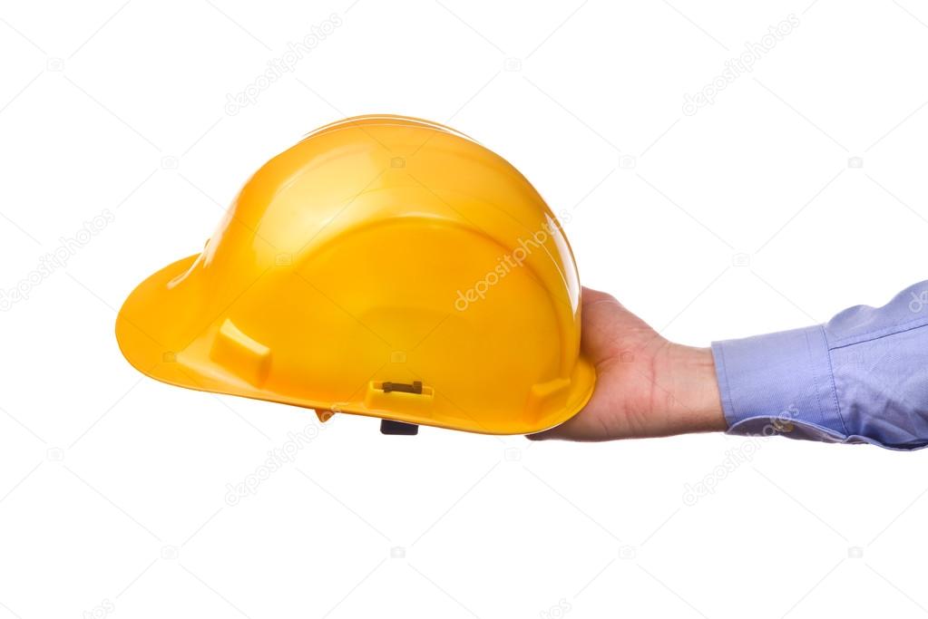 Male worker's hand holding yellow industrial protective helmet.