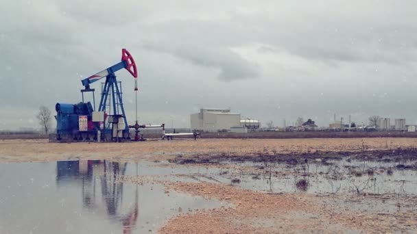 Pumpjack oljepump på naturgas i fältet pumpa från olja väl under vintersäsongen snofall — Stockvideo
