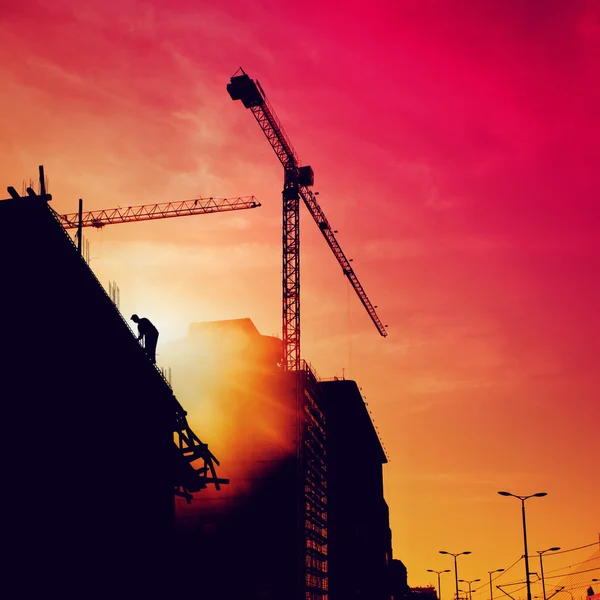 Trabajador de la construcción en un edificio al atardecer —  Fotos de Stock