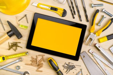 Dijital Tablet ve atölye tablosundaki çeşitli marangozluk aletleri