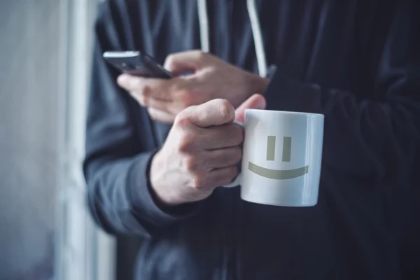 Kaffee trinken und morgens mit dem Handy SMS schreiben — Stockfoto