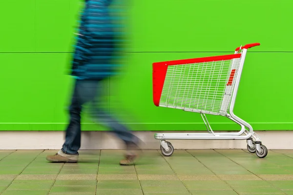 Homem andando pelo carrinho de compras vazio Trolley — Fotografia de Stock