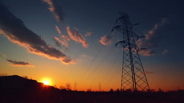 Σιλουέτα της γραμμής ηλεκτρικούς πυλώνες και δύναμη, ηλιοβασίλεμα, πάροδο του χρόνου — Αρχείο Βίντεο