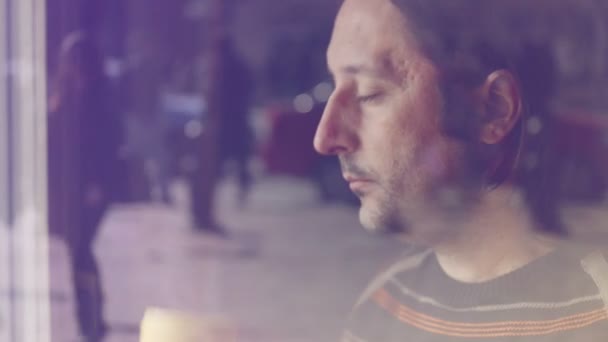 Одинокий белый мужчина пьет кофе, думает и смотрит в окно — стоковое видео