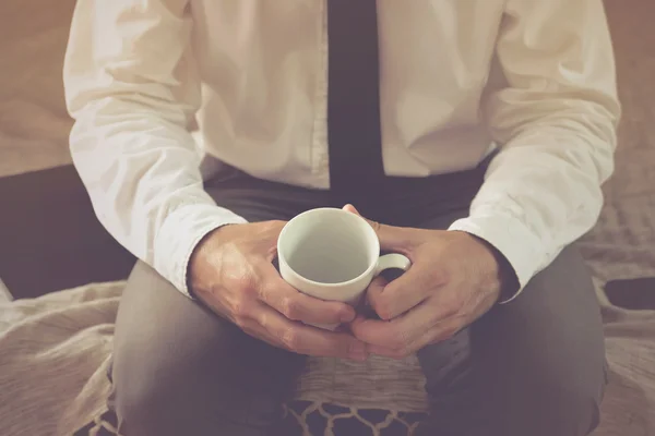 Uomo d'affari solitario in camera d'albergo con tazza di caffè vuota — Foto Stock