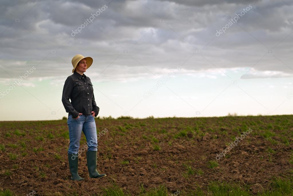 Female Farmer Standing on Fertile Agricultural Farm Land Soil