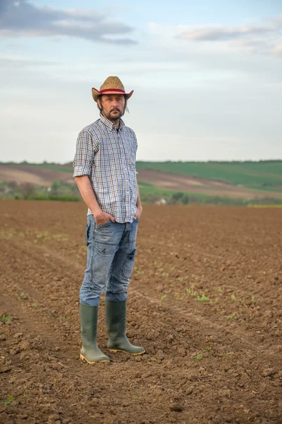 Granjero macho parado en tierra fértil de la granja agrícola —  Fotos de Stock
