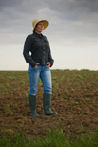 Kvinnliga jordbrukare står på bördig jordbruksmark gård jord — Stockfoto