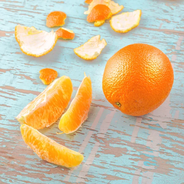 Frutta e buccia d'arancia dolce fresca su fondo rustico in legno — Foto Stock