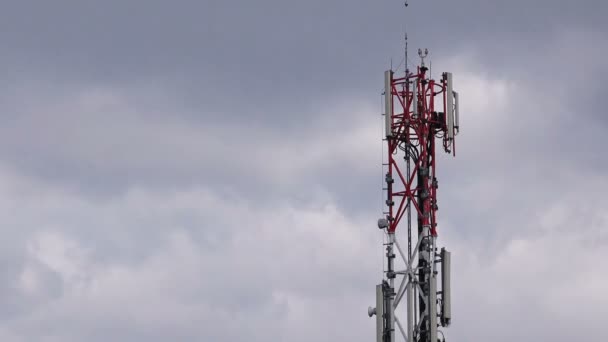 GSM Antenna Transmitters on Red and White Industrial Communication Tower