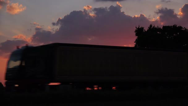 Lastbil silhuett i kväll solnedgången genom landsbygden — Stockvideo