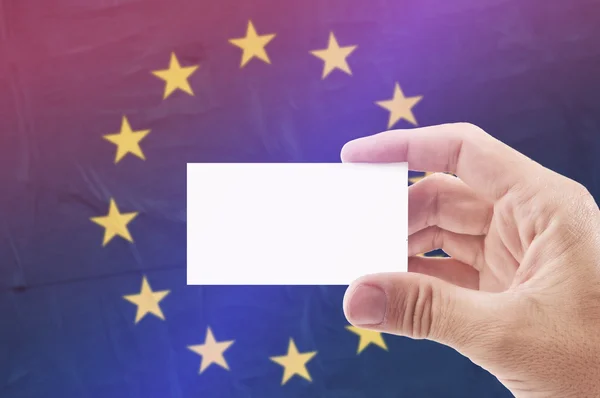 Man Holding Blank Business Card Against European Unionl Flag — Stock Photo, Image