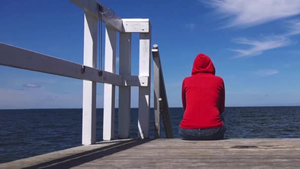 Mujer solitaria con camisa roja al borde del muelle — Vídeos de Stock