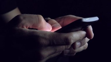 Adam karanlık odada SMS metin mesajı gönderme