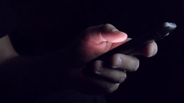 Man sending SMS text message in dark room — Stock Video