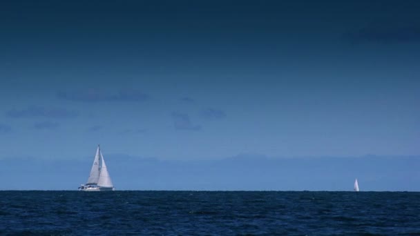 Kleines Segelboot auf hoher See, Segelboot kreuzt vor der Küste — Stockvideo