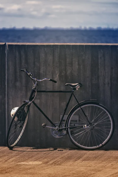 Klasický Vintage černé kolo opřel se o zeď — Stock fotografie