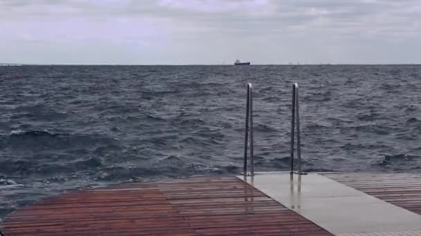 Хвилі розбризкують дерев'яний океанський пірс в штормовий день — стокове відео