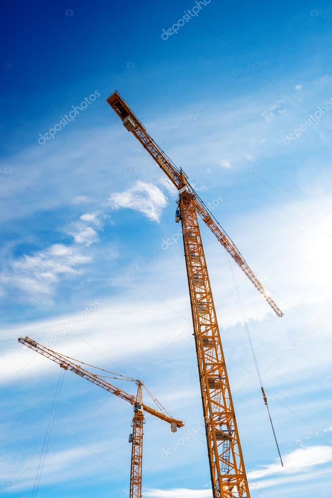 Two Industrial Cranes Working on Construction Site