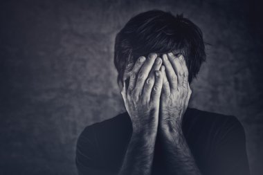 Grief, man covering fsce and crying