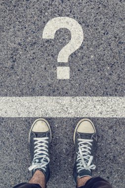 Young man standing on the street questioning