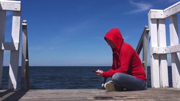 Молодая женщина смс с мобильного телефона — стоковое видео