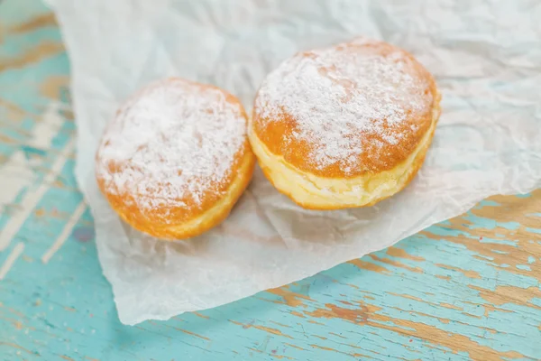 Sweet sugary donuts on rustic table — Stock Photo, Image