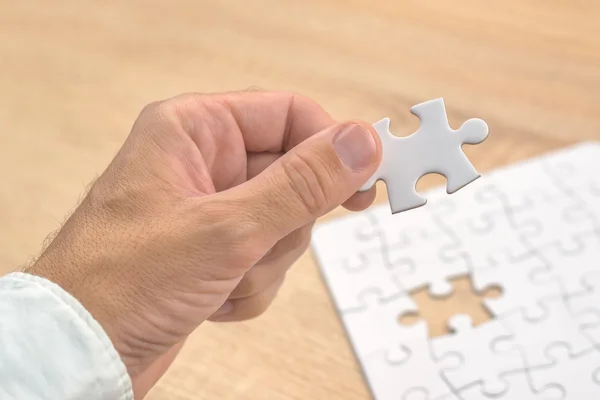 Geschäftsmann Hand legt ein fehlendes Teil in Puzzle — Stockfoto