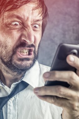 Angry businessman received frustrating SMS message clipart