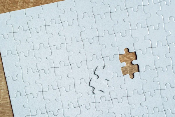 Piece chybianie z puzzli na drewnianym stole — Zdjęcie stockowe