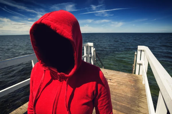 Ansiktslösa Hooded oigenkännlig kvinna vid havet Pier, bortförande Co — Stockfoto