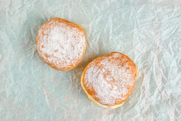 Rosquillas dulces y azucaradas sobre papel de hornear —  Fotos de Stock