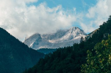 Triglav mountain peak in Slovenia with its summit enclosed in drifting cloud on a summer day. Selective focus.