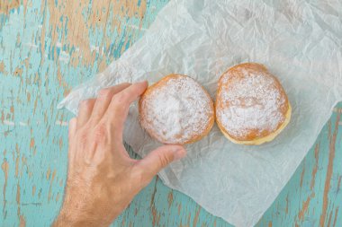 Rustik masada tatlı şekerli çörek için el ulaşır