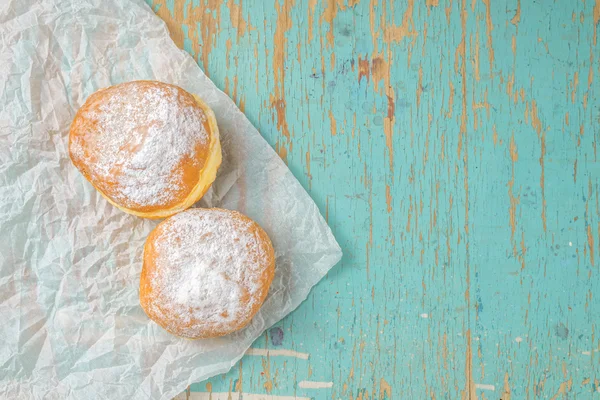 Sweet sugary donuts on rustic table — Stock Photo, Image