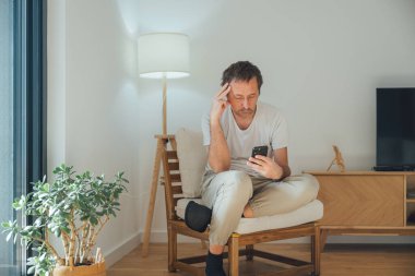 Sıkıcı, tembel, olgun bir adam zamanını akıllı telefondan kaydırarak boşa harcıyor. Amaçsızca gezinirken oyalanıyor ve uzaklaşıyor. Seçici odak