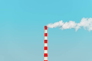 Endüstriyel baca açık mavi gökyüzüne karşı beyaz duman yayıyor, hava kirliliği kavramı. Seçici odak.